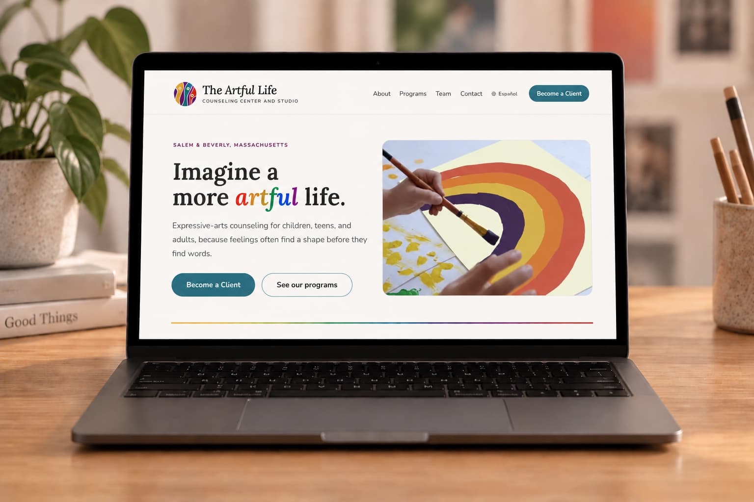The Artful Life homepage redesign by Tiphanie Rafter, shown on a laptop on a wooden desk