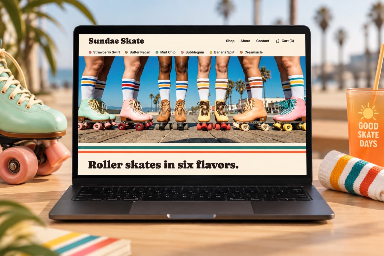 A laptop showing the Sundae Skate homepage, resting on a wooden table on the Venice boardwalk, six pairs of roller skates in different flavor colorways lined up in a row on the screen